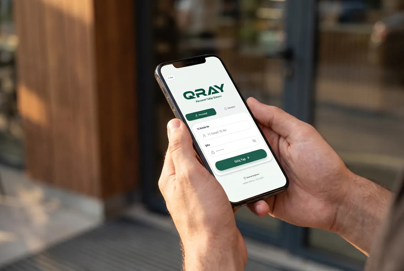 QRAY employee time clock app on a smartphone